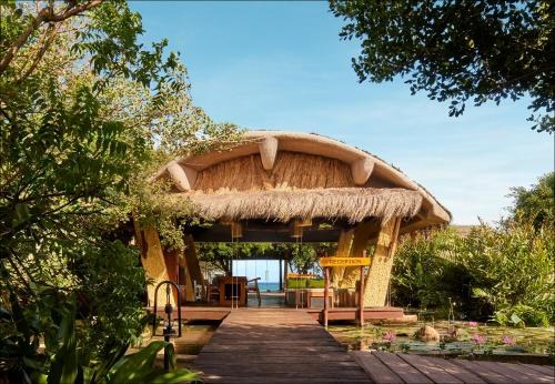 Thatched pavilion on a boardwalk in a tropical garden