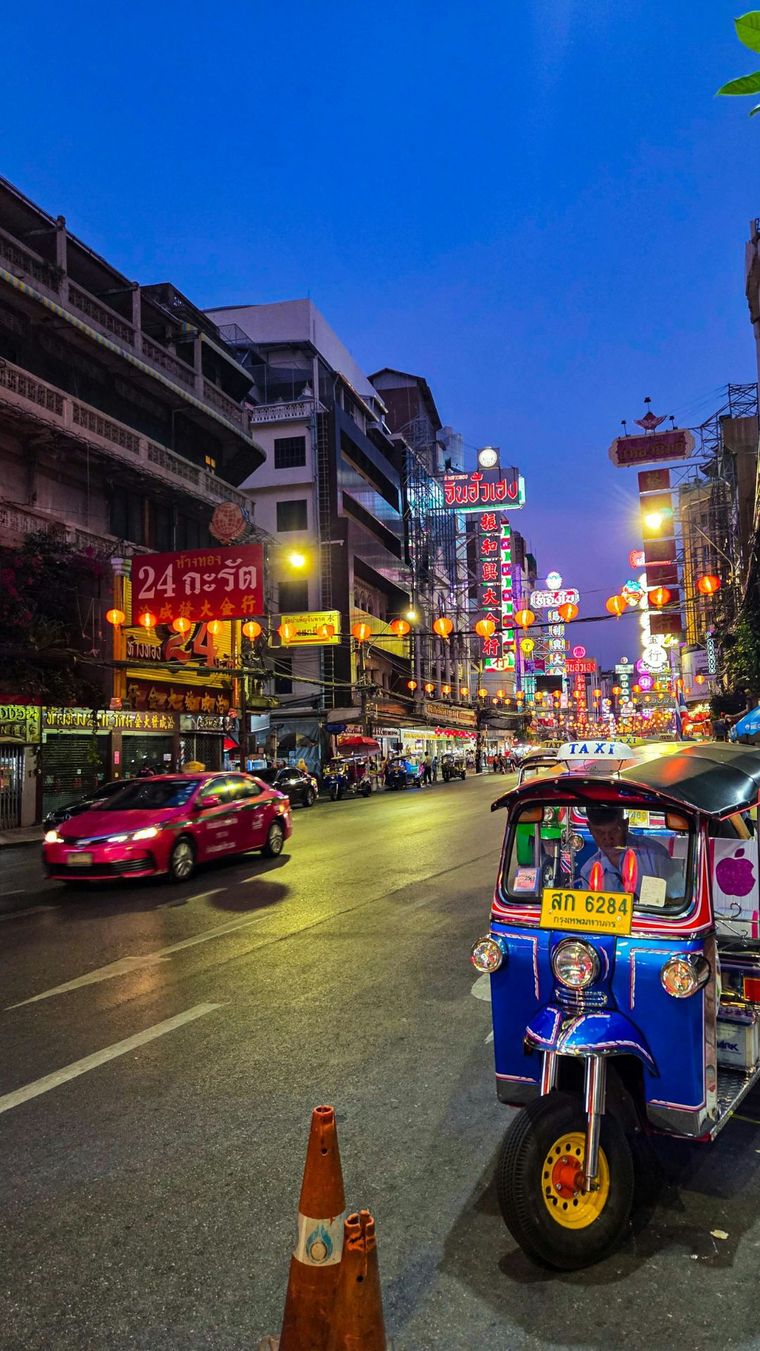 Tuk-tuk on a neon-lit Bangkok street