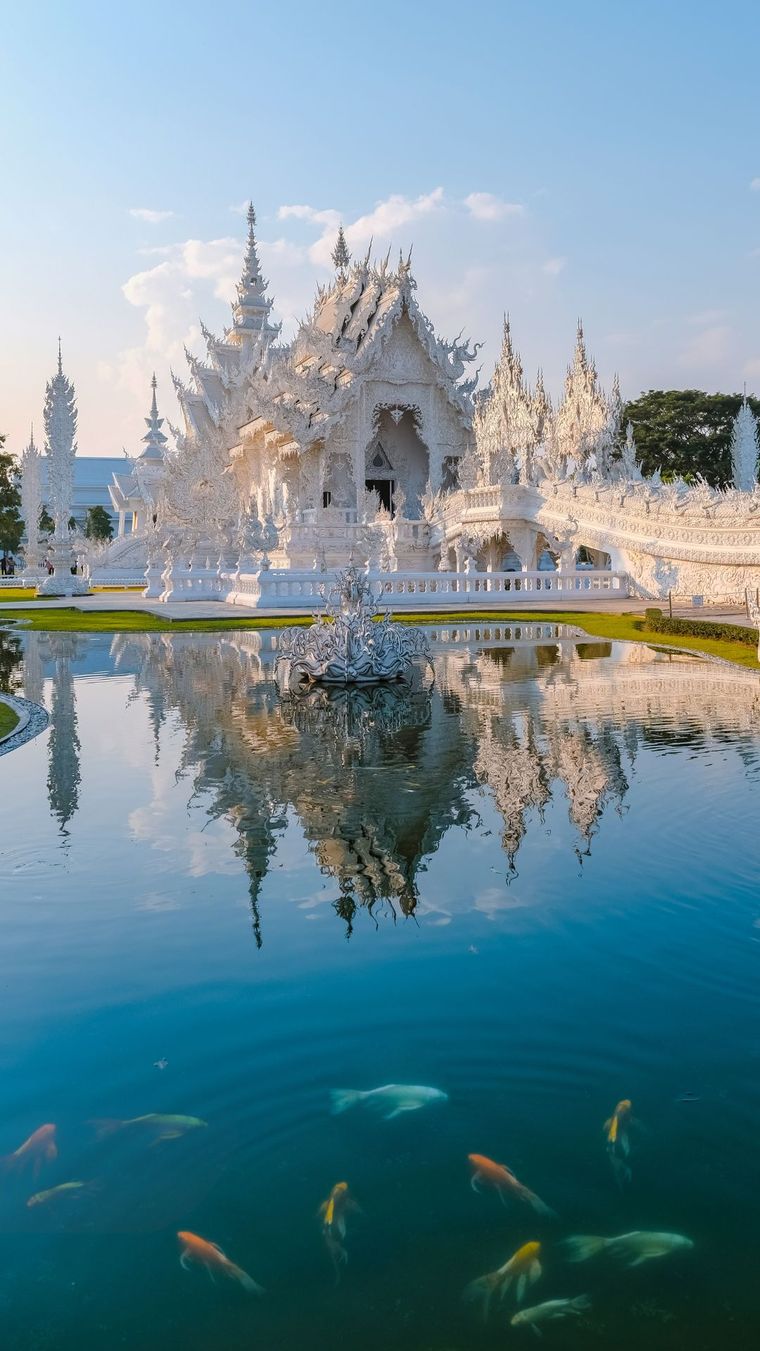 White temple reflected in a koi pond